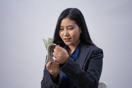 Téléchargez les photos : Portrait d'une jeune femme d'affaires asiatique avec de l'argent, plan de studio, concept d'entreprise, arrière-plan isolé - en image libre de droit
