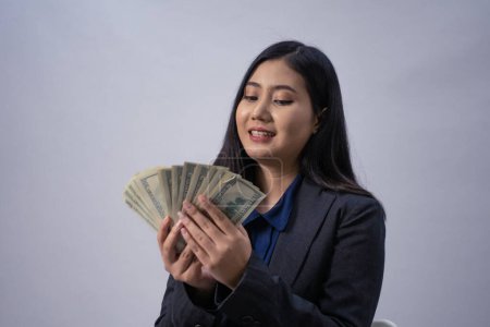 Photo for Portrait of a young Asian business woman with money, studio shot, business concept, isolated background - Royalty Free Image
