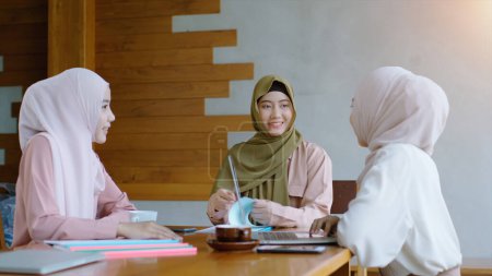 Photo for Upwardly mobile Asian Muslim business entrepreneur SME start up group of young women discussing sale and marketing analysis, Asian Muslim SME teamwork e-commerce concept - Royalty Free Image