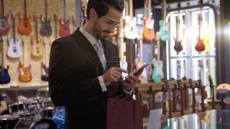 Téléchargez les photos : Un musulman mobile utilisant le paiement intelligent pour payer un produit dans un terminal de vente avec paiement d'identification nfc pour la vérification et l'authentification - en image libre de droit