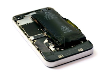Foto de Batería de polímero de iones de litio hinchada dentro de un teléfono móvil sobre fondo blanco aislado - Imagen libre de derechos