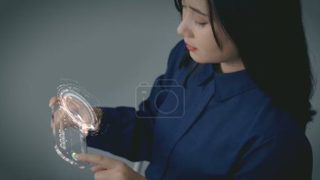 Foto de Un concepto futurista de comunicación móvil de una hermosa mujer asiática utilizando una tecnología de tableta móvil transparente avanzada - Imagen libre de derechos