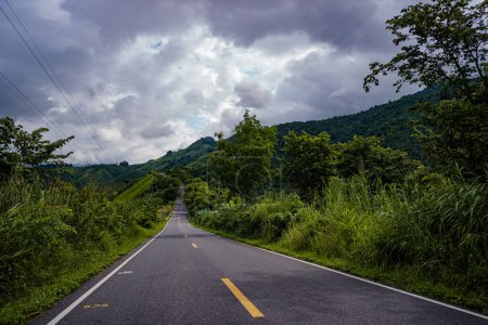 Photo for Countryside road passing through the serene lush greenery and foliage tropical rain forest mountain landscape on the Doi Phuka Mountain reserved national park the northern Thailand - Royalty Free Image
