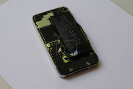 Téléchargez les photos : Batterie lithium ion polymère gonflée à l'intérieur d'un téléphone portable sur fond blanc isolé - en image libre de droit
