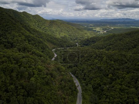Foto de Concepto logístico vista aérea de la carretera rural - autopista que pasa a través de la vegetación exuberante serena y follaje tropical selva tropical paisaje de montaña - Imagen libre de derechos