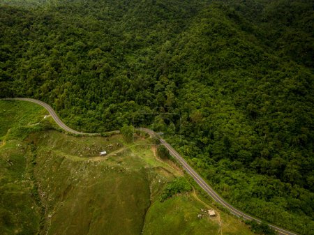Foto de Concepto logístico vista aérea de la carretera rural - autopista que pasa a través de la vegetación exuberante serena y follaje tropical selva tropical paisaje de montaña - Imagen libre de derechos