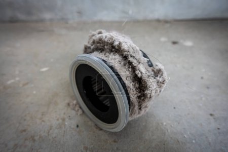 Téléchargez les photos : Filtre aspirateur ménager obstrué par la poussière, les acariens, les poils et la fourrure d'animal après un nettoyage ménager intensif : allergie, concept non hygiénique - en image libre de droit