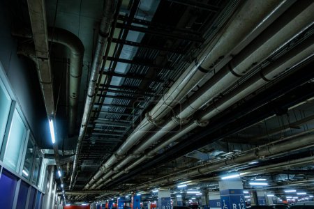 Téléchargez les photos : Pipelines dans le stationnement souterrain d'une raffinerie de pétrole et de gaz courir le long du plafond, desservant le complexe industriel - en image libre de droit