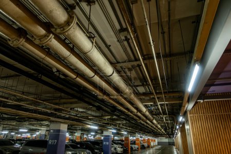 Foto de Tuberías en el aparcamiento subterráneo de una refinería de petróleo y gas a lo largo del techo, el servicio del complejo industrial - Imagen libre de derechos