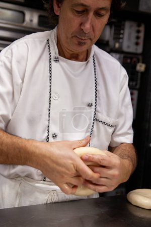 Téléchargez les photos : Portrait d'un pâtissier avec de la pâte sucrée à la main - en image libre de droit