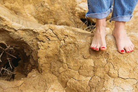 Foto de Pies femeninos descalzos en un suelo desértico en libertad - Imagen libre de derechos