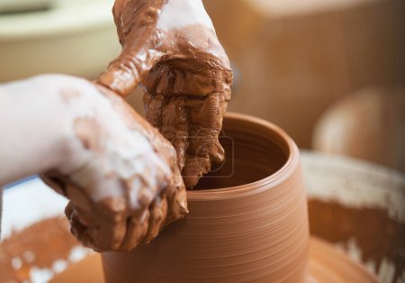 Ceramista mano haciendo un jarrón con arcilla en la rueda del alfarero