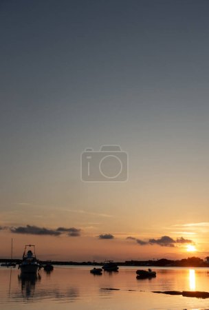 Photo for SUNSET ON THE SEA WITH BOATS ON THE SHORE, VERTICAL PHOTO - Royalty Free Image