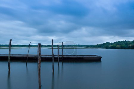 Foto de Puesta de sol en el lago con pontón flotante en tonos azules con ambiente relajado - Imagen libre de derechos