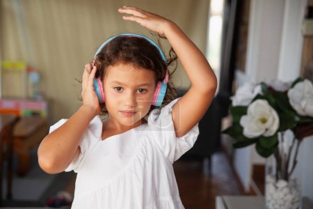 Foto de Retrato de niña escuchando atentamente la música con auriculares - Imagen libre de derechos