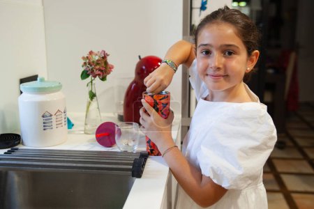 Photo for Beautiful happy girl preparing chocolate milkshake in the kitchen - Royalty Free Image