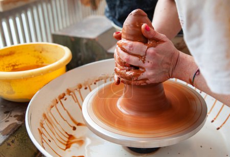 Téléchargez les photos : Détail des mains d'une femme potier à la roue du potier modelant un morceau d'argile. - en image libre de droit