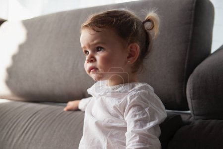 Photo for Detail of a portrait of a baby girl attentive to the tv - Royalty Free Image