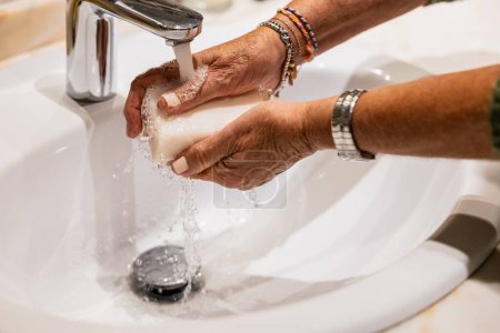 Foto de Mujer madura lavándose las manos con jabón - Imagen libre de derechos