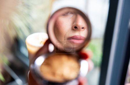 Téléchargez les photos : Détail rapproché de la bouche d'une femme reflétée dans le miroir d'une poudre de maquillage compacte - en image libre de droit