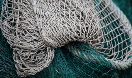 Photo for Close-up detail of several green and white intermingled nets piled up in the harbor - Royalty Free Image