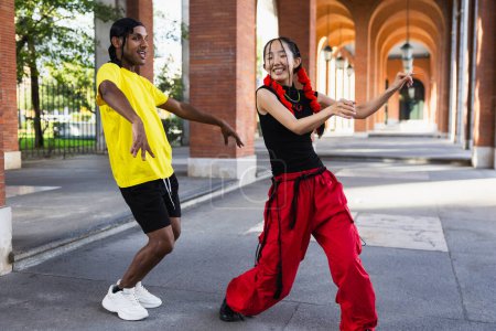 Foto de Joven pareja multirracial bailando afro dance en la calle divirtiéndose - Imagen libre de derechos