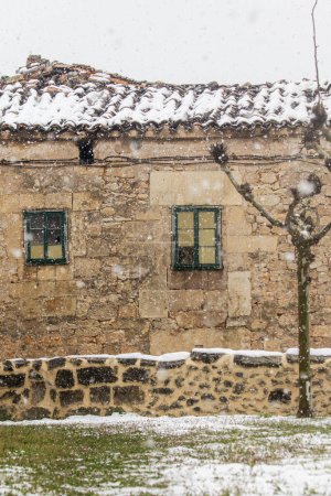 Foto de Corte de una casa rural de piedra con pequeñas ventanas en un día nevado y nublado - Imagen libre de derechos