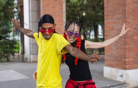 Téléchargez les photos : "Deux danseurs en harmonie, mettant en valeur leur passion pour la danse à bras ouverts et des pas synchronisés en tenue urbaine décontractée." - en image libre de droit