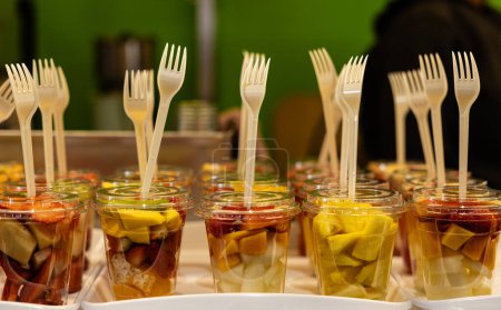 Foto de Surtido de tazas de fruta fresca con tenedores convenientes sobresaliendo, arreglado para bocadillos saludables rápidos. - Imagen libre de derechos