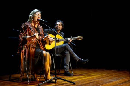 Téléchargez les photos : "Moment captivant avec un chanteur et guitariste flamenco se produisant sur scène, mettant en valeur la musique culturelle." - en image libre de droit