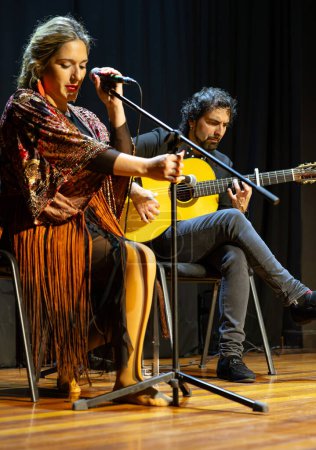 Photo for "A focused flamenco singer and guitarist immerse themselves in a soul-stirring musical performance." - Royalty Free Image
