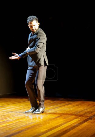 "Focused male flamenco dancer on stage, showcasing a traditional dance pose in professional attire."