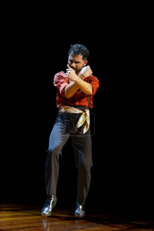 Photo for Intense and focused, a male flamenco dancer commands the stage with a powerful and intricate arm cross. - Royalty Free Image
