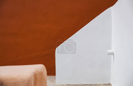 Foto de Un sorprendente contraste de paredes rojas y blancas crujientes, mostrando la belleza minimalista del diseño arquitectónico egeo. - Imagen libre de derechos