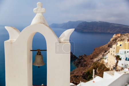 Photo for A classic view of a whitewashed bell tower in Santorini, with the tranquil Aegean Sea stretching into the horizon. - Royalty Free Image