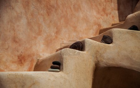 Close-up of the earthen tones and smooth curves of traditional Santorini architecture, highlighted by natural volcanic stones.
