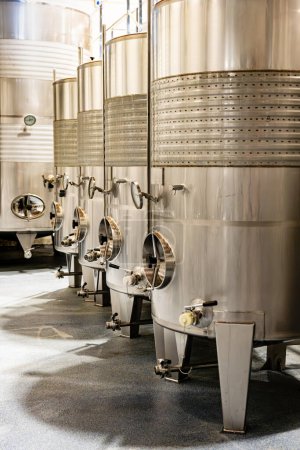 Moderne Edelstahl-Gärtanks, die für die Weinproduktion verwendet werden, unterstreichen die eleganten, klaren Linien eines professionellen Weinguts.