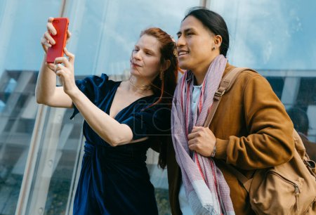 Friends enjoying their journey together, taking a selfie to capture the moment against an urban backdrop.