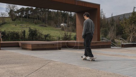 A skateboarder rides peacefully through an urban park, blending the tranquility of green spaces with the energy of skateboarding.