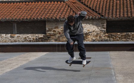 A skateboarder is frozen in time while executing a mid-air trick, set against the contrasting backdrop of a rustic stone building.