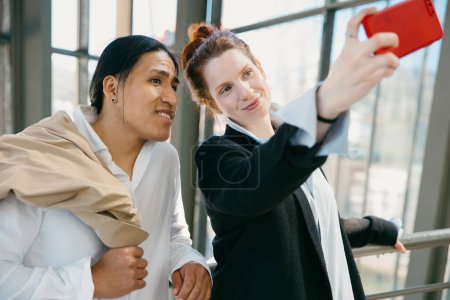 Téléchargez les photos : Un jeune couple heureux capture un selfie pour se souvenir de leur agréable voyage dans un musée de la ville, se prélassant dans l'excitation du voyage. - en image libre de droit