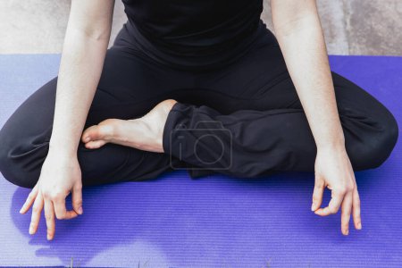 Foto de Detalle de una mujer practicando yoga en una posición relajada. - Imagen libre de derechos