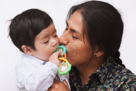 Ein ecuadorianischer Vater mit traditionellem Zopf küsst sein Baby sanft, symbolisiert Liebe und kulturelles Erbe.