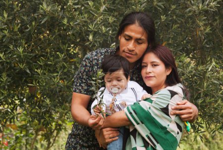 Téléchargez les photos : "Parents équatoriens avec leur bébé dans un jardin, partageant un moment d'amour et de connexion." - en image libre de droit