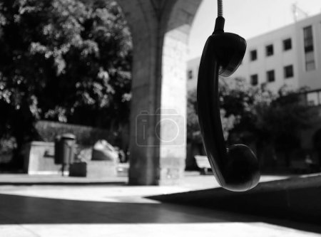 Téléchargez les photos : Téléphone public accroché à son fil dans une partie isolée du centre-ville de Guadalajara. - en image libre de droit