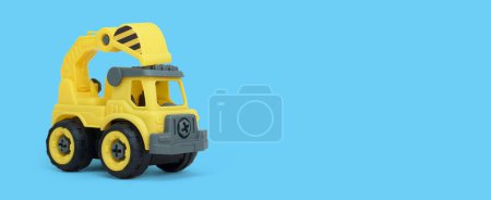 Foto de Juguete de camión mezclador de concreto plástico amarillo aislado sobre fondo azul. camión de la vechícula de la construcción con un espacio de copia para la bandera de la tienda de juguetes. - Imagen libre de derechos