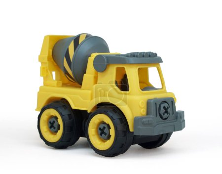Foto de Juguete de camión mezclador de concreto plástico amarillo aislado sobre fondo azul. camión de construcción vechicle. - Imagen libre de derechos