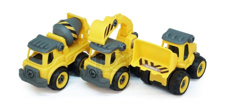Téléchargez les photos : Lourds jouets de construction aligner dans une rangée isolée sur fond blanc. jouet en plastique composé de camion, mélangeur et chargeur. - en image libre de droit