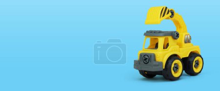 Photo for Yellow plastic truck toy isolated on blue background. construction vechicle truck with a copy space for banner of toy store. - Royalty Free Image
