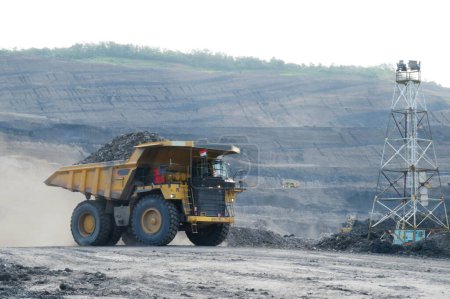 Foto de Gran camión amarillo transportando carbón de la cantera. industria de minas de carbón - Imagen libre de derechos